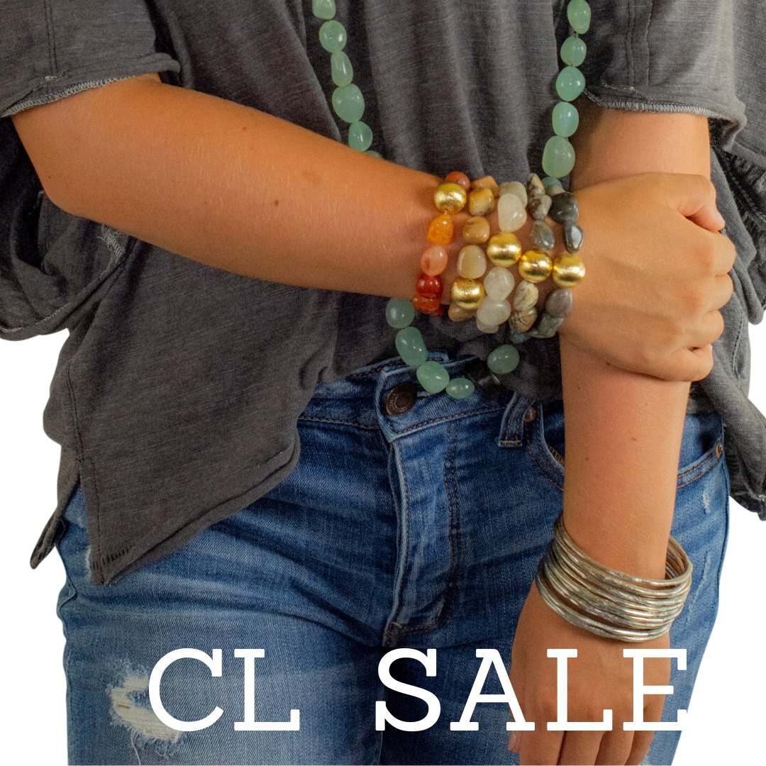 Model wearing beaded gemstone necklace and matching stretch bracelets. Link directs user to Marked down Sale menu