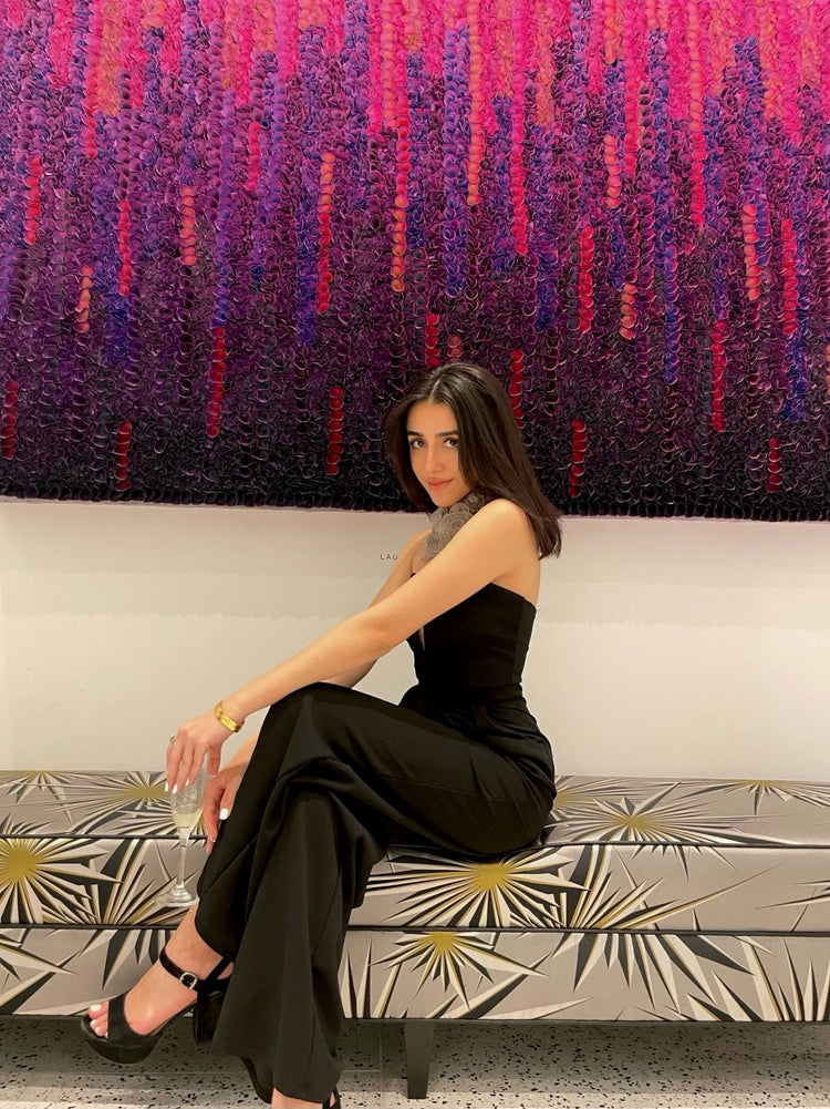 beautiful woman sitting on bench in evening wear wearing crochet rhodium necklace. Link directs user to one of a kind menu